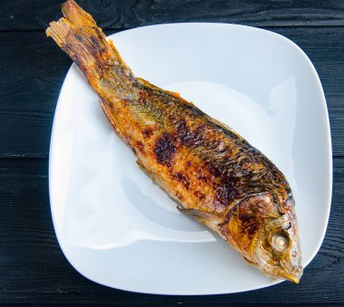 Kızarmış balık tabakta servis edilir.