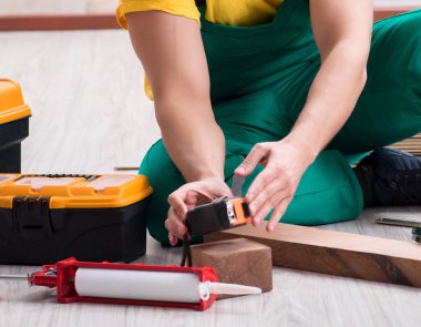 Müteahhit lamine ahşap zemin üzerinde çalışıyor.