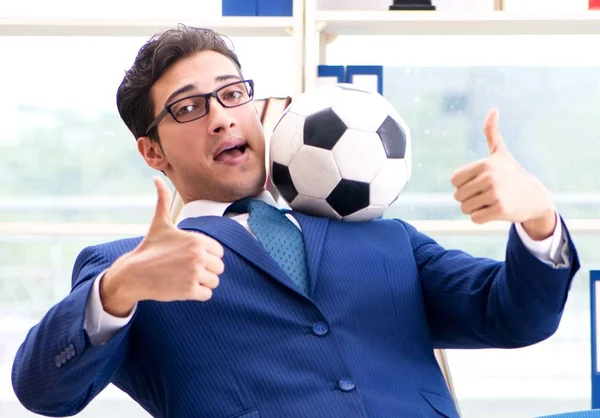 Бизнесмен играет в футбол в офисе — стоковое фото