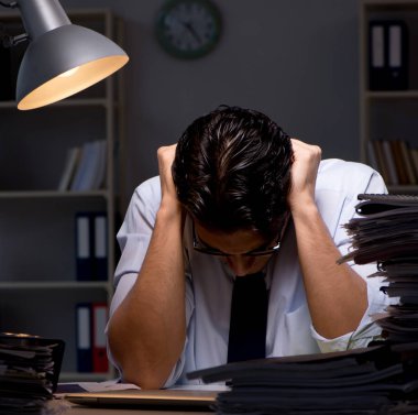 Genç işadamı geç saatlere kadar ofiste çalışıyor.