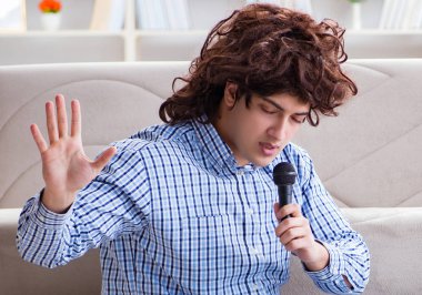 Evde karaoke yapan komik adam.
