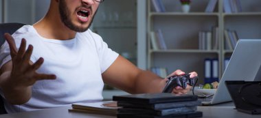 Genç adam ofiste saatlerce oyun oynuyor.