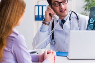 Doktor hastanın röntgen görüntülerini inceliyor.