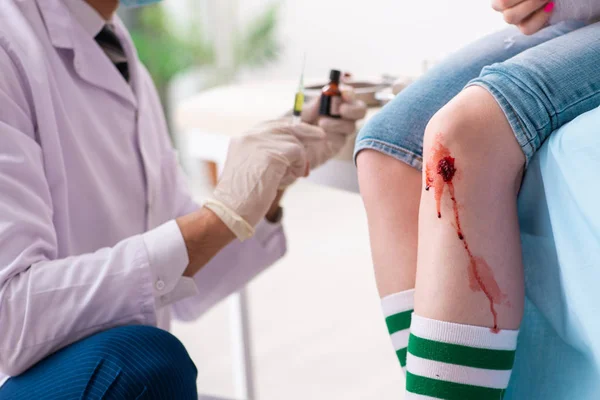 Leg injured young woman visiting male doctor — Stock Photo, Image