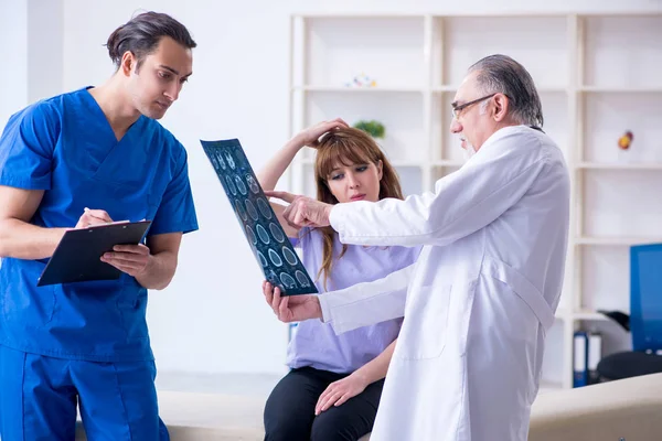 Two doctors examining young woman — Stock Photo, Image