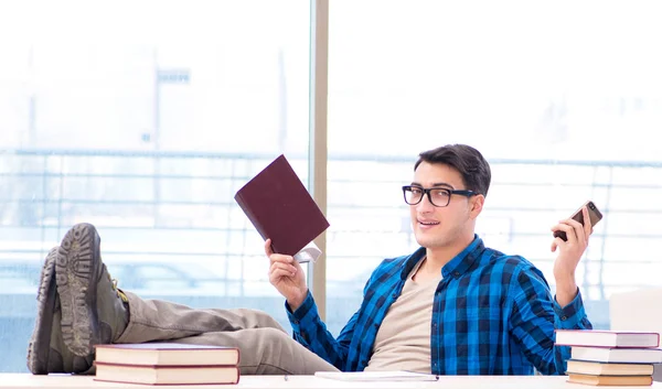 Student studiujący w pustej bibliotece z książką przygotowującą się do ex — Zdjęcie stockowe