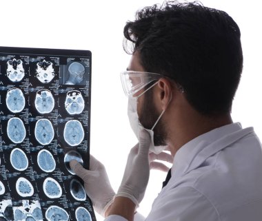 Röntgen görüntülerine bakan genç doktor beyazda izole edilmiş.