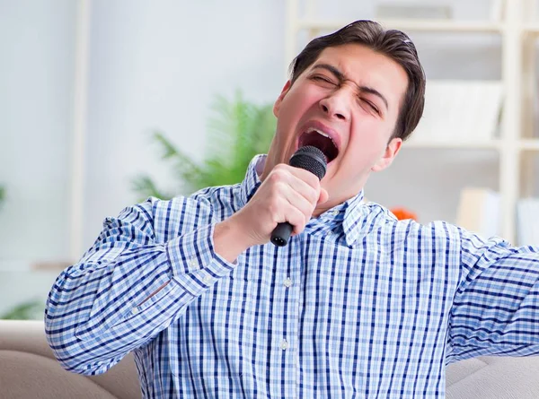 Hombre divertido cantando canciones en karaoke en casa —  Fotos de Stock