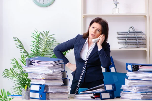 Zakenvrouw van middelbare leeftijd ongelukkig met buitensporig werk — Stockfoto