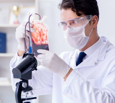 Hastane kliniğinde kan örnekleriyle çalışan bir doktor.