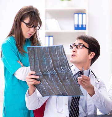 Üç doktor röntgen sonuçlarını tartışıyor