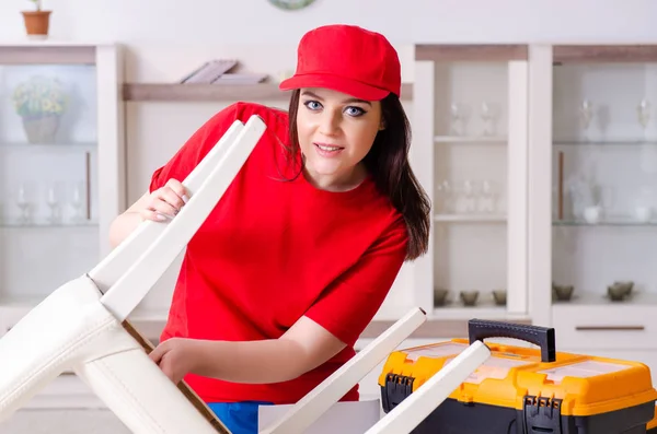 Giovane donna che ripara sedia a casa — Foto Stock