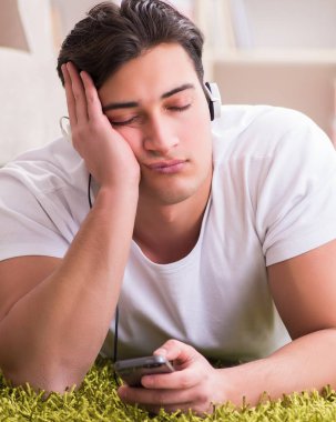 Evde müzik dinleyen genç bir öğrenci.