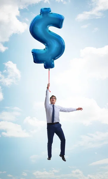 Dolar işareti üzerinde uçan iş adamı şişme balon — Stok fotoğraf