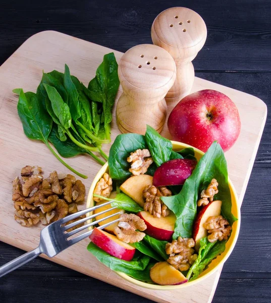 Salada de espinafre com nozes e maçãs servidas na mesa — Fotografia de Stock