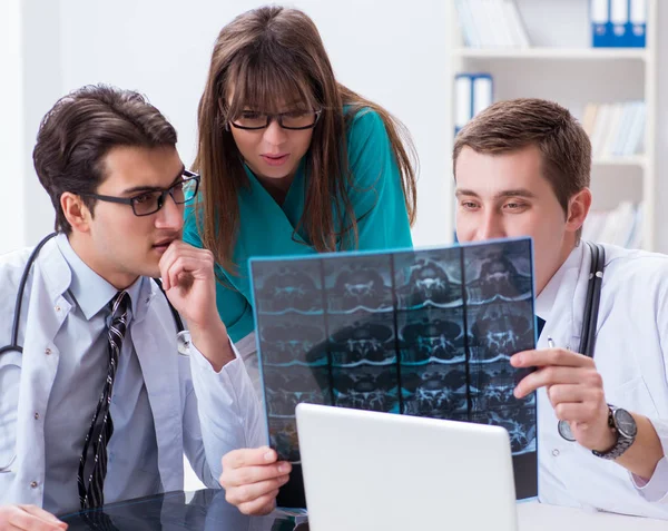 Tre läkare diskuterar skanningsresultat av röntgenbild — Stockfoto