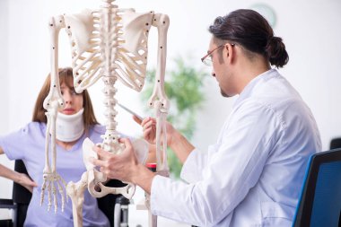 Tekerlekli sandalyedeki genç kadın erkek doktoru ziyaret ediyor. 