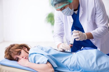 Kadın hasta klinikte iğne oluyor. 