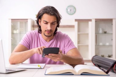 Evde sınava hazırlanan genç bir erkek öğrenci.