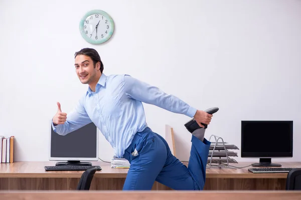 Junger gutaussehender Geschäftsmann macht Übungen am Arbeitsplatz — Stockfoto