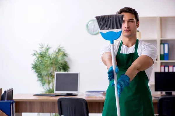 Jonge knappe aannemer schoonmaken van het kantoor — Stockfoto