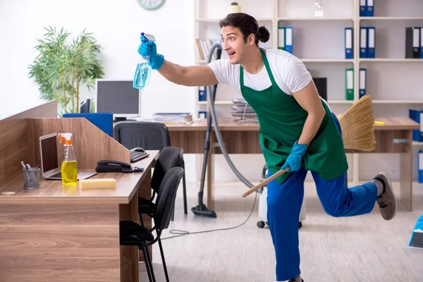 Jonge knappe aannemer schoonmaken van het kantoor — Stockfoto