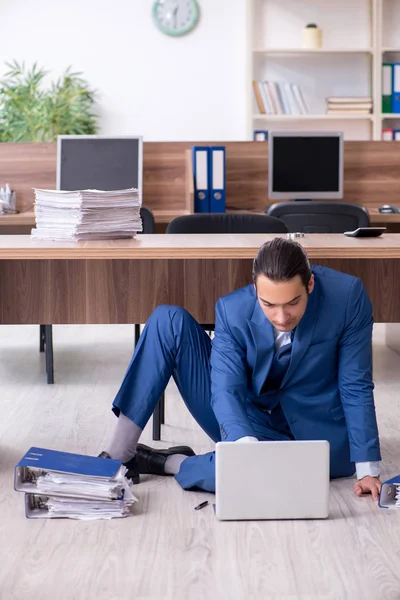 Joven empleado masculino y demasiados trabajan en la oficina — Foto de Stock