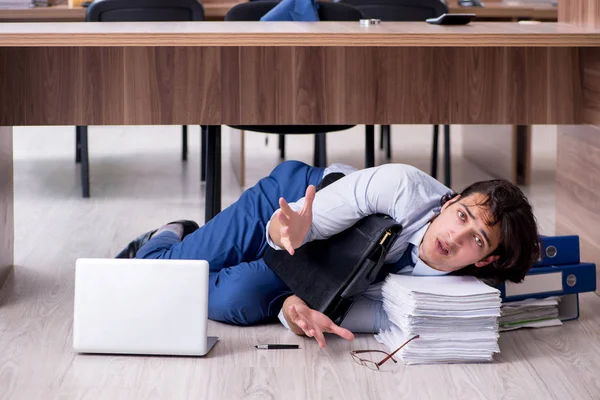 Joven empleado masculino y demasiados trabajan en la oficina — Foto de Stock