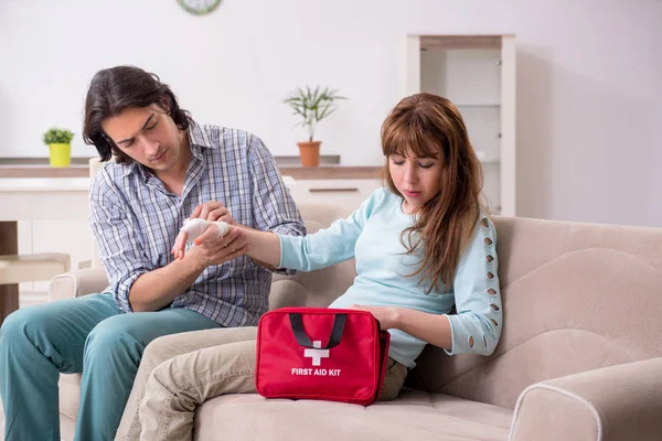 Young couple in first aid concept at home — Stock Photo, Image