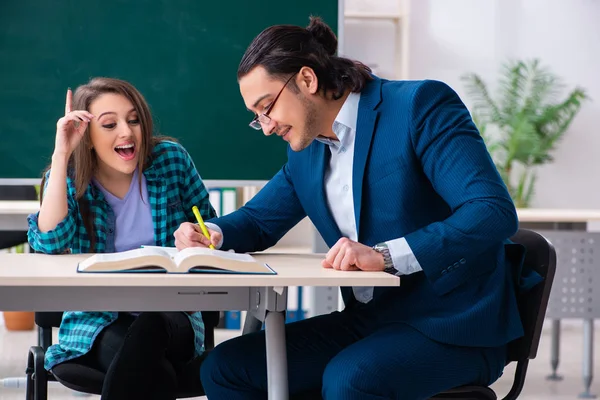 Mladý pohledný učitel a studentka ve třídě — Stock fotografie