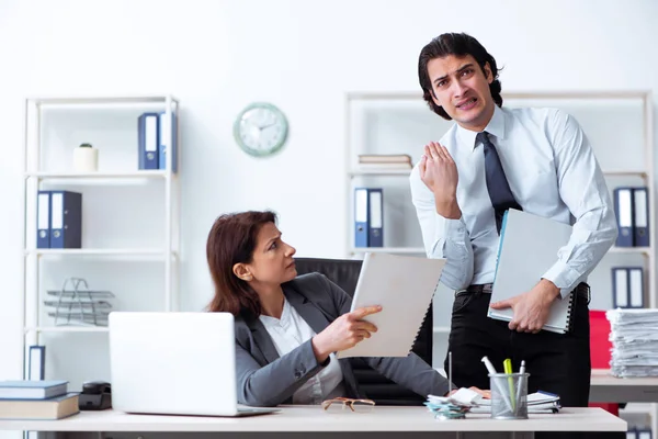 Old female boss and young male employee in the office — Stock Photo, Image