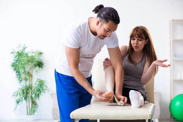 Leg injured woman visiting young doctor traumatologist — Stock Photo, Image