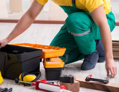 Müteahhit lamine ahşap zemin üzerinde çalışıyor.