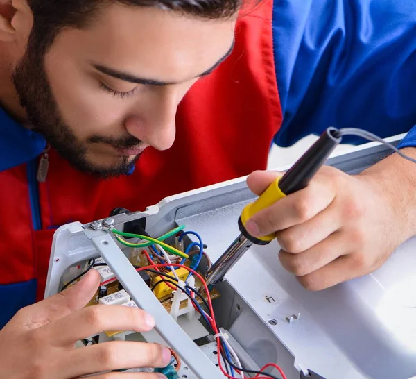 Ung reparatör fastställande och reparation av mikrovågsugn — Stockfoto