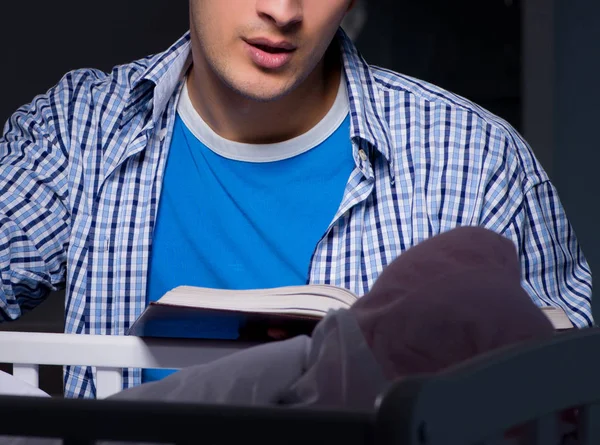 Giovane studente che fa i compiti e si prende cura del neonato — Foto Stock