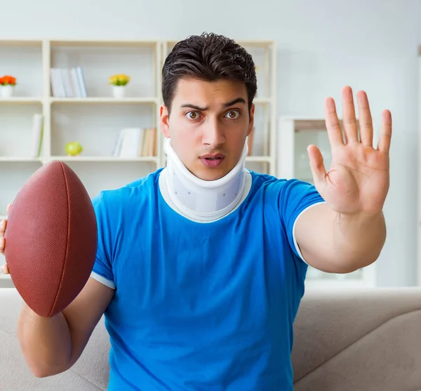 Homem com lesão no pescoço assistindo futebol americano em casa — Fotografia de Stock