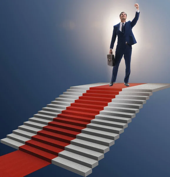 Joven hombre de negocios subir escaleras y alfombra roja — Foto de Stock