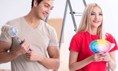 Ev tadilatı sırasında genç bir aile boya işi yapıyor.