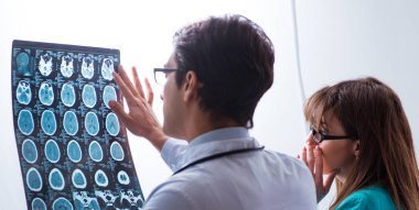 Üç doktor röntgen sonuçlarını tartışıyor