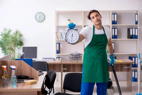 Jovem empreiteiro bonito limpando o escritório — Fotografia de Stock