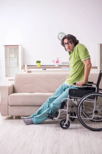 Jovem estudante do sexo masculino em cadeira de rodas em casa — Fotografia de Stock