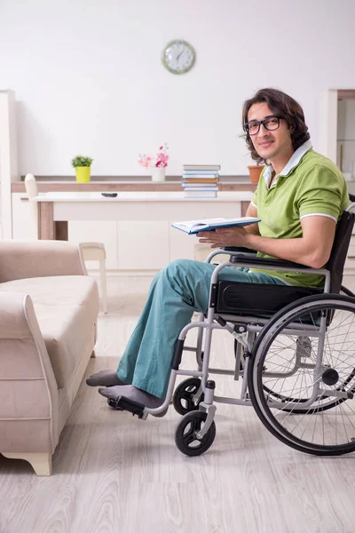 Jeune étudiant en fauteuil roulant à la maison — Photo