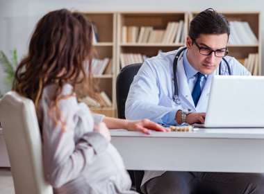 Hamile kadın muayene için doktoru ziyaret ediyor.