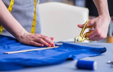 Kadın terzi dikiş dikmek için dikiş dikiyor.