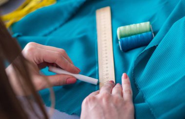 Kadın terzi dikiş dikmek için dikiş dikiyor.