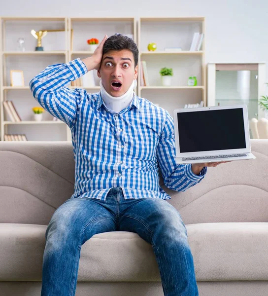 Man frilansare i en halskrage nackstöd arbetar hemifrån — Stockfoto