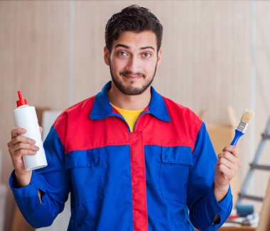 Yooung marangoz boyayla uğraşıyor.