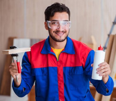 Yooung marangoz boyayla uğraşıyor.