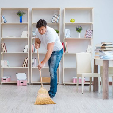 Adam evi temizliyor.