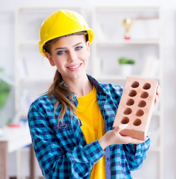 Mujer con ladrillo en concepto de construcción — Foto de Stock